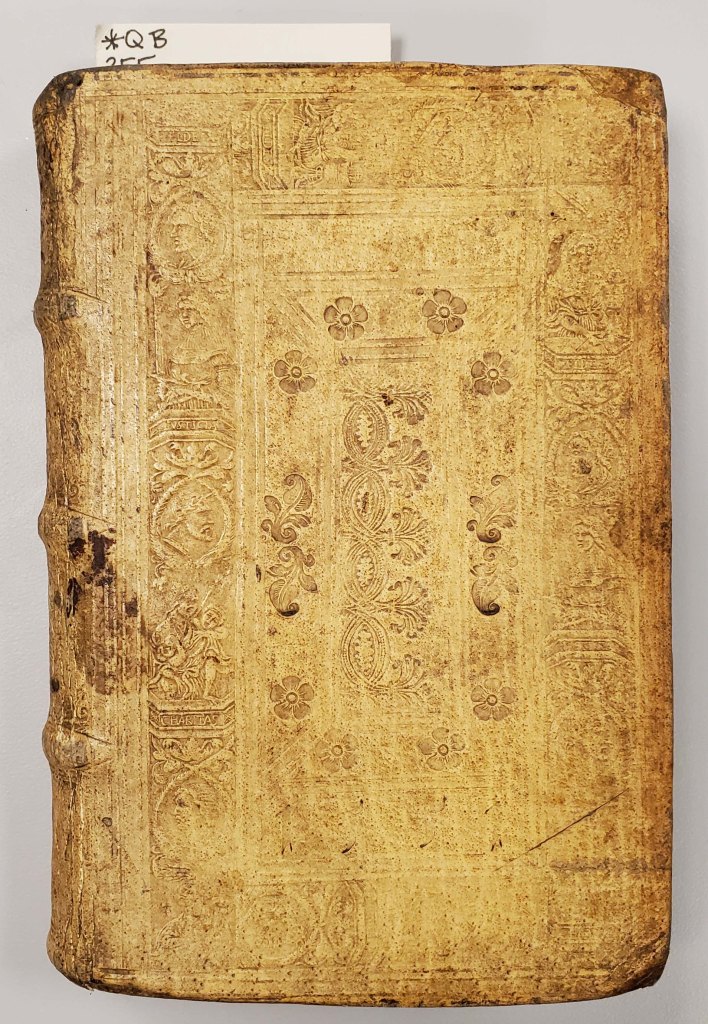 Book cover with carvings including flowers and men's faces
